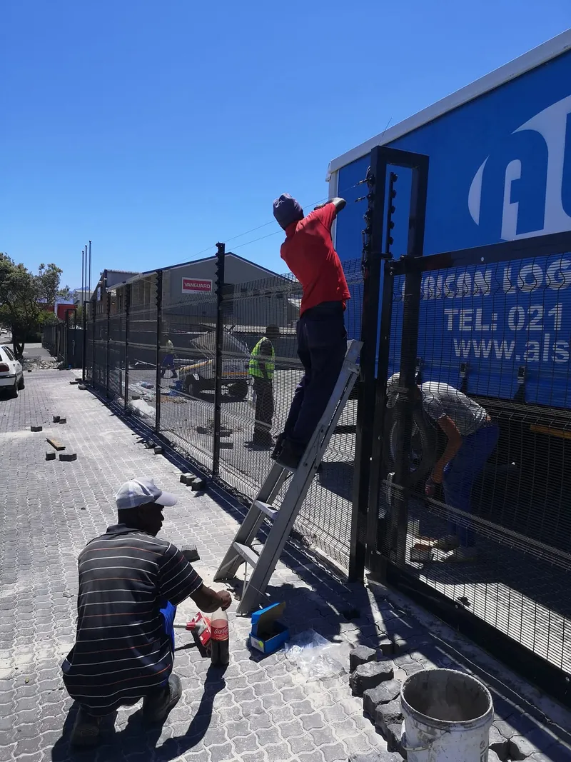 D and H Fencing team installing clearview mesh and electric top at Cape Town logistics depot