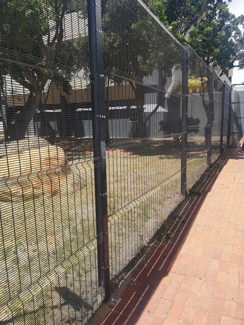 Long run of clearview mesh fence beside brick walkway at Cape Town commercial site