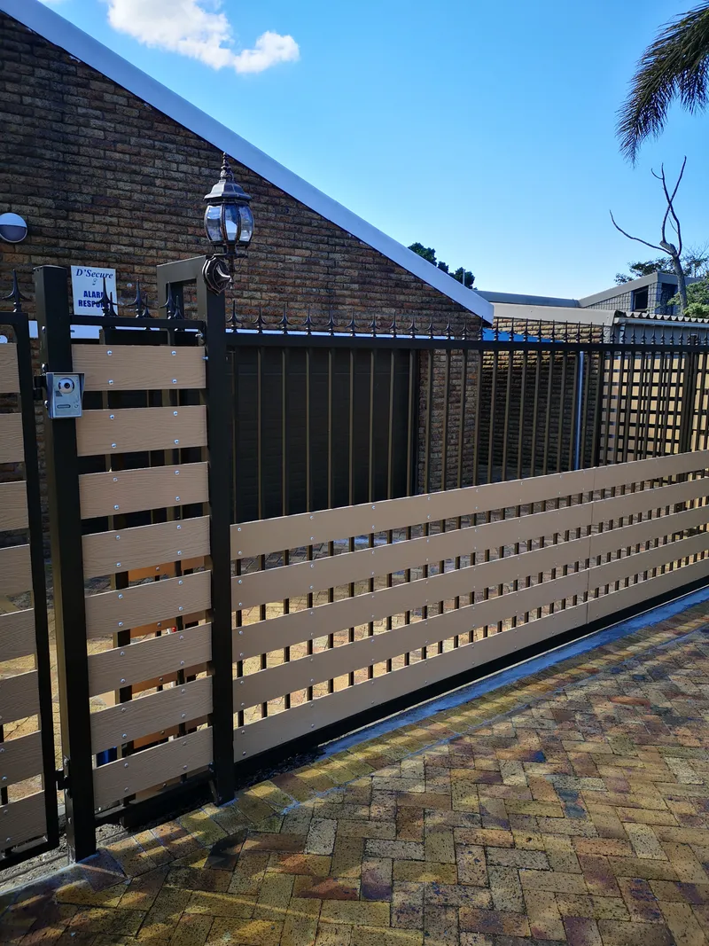 Composite horizontal slat driveway sliding gate with spike-top palisade panel in Cape Town residential property