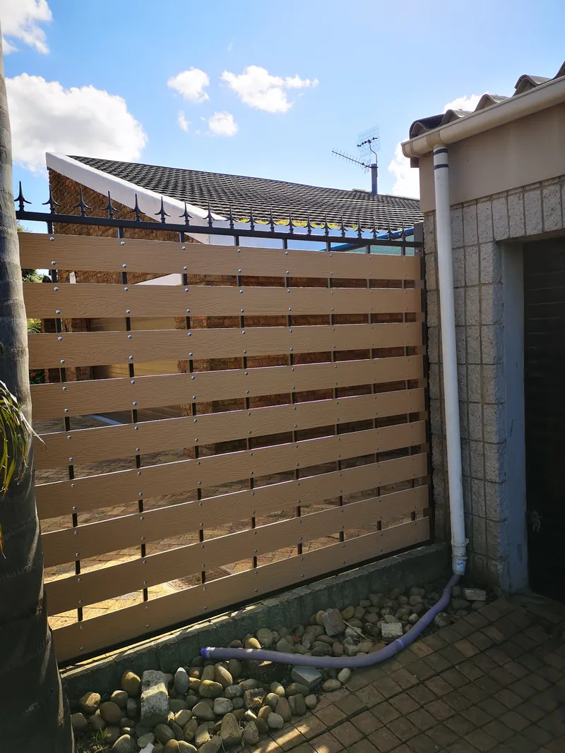 Composite horizontal slat side boundary fence with palisade spike tops at Cape Town home