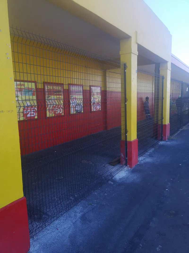 Clearview mesh fencing protecting commercial shop veranda and promotional posters Cape Town