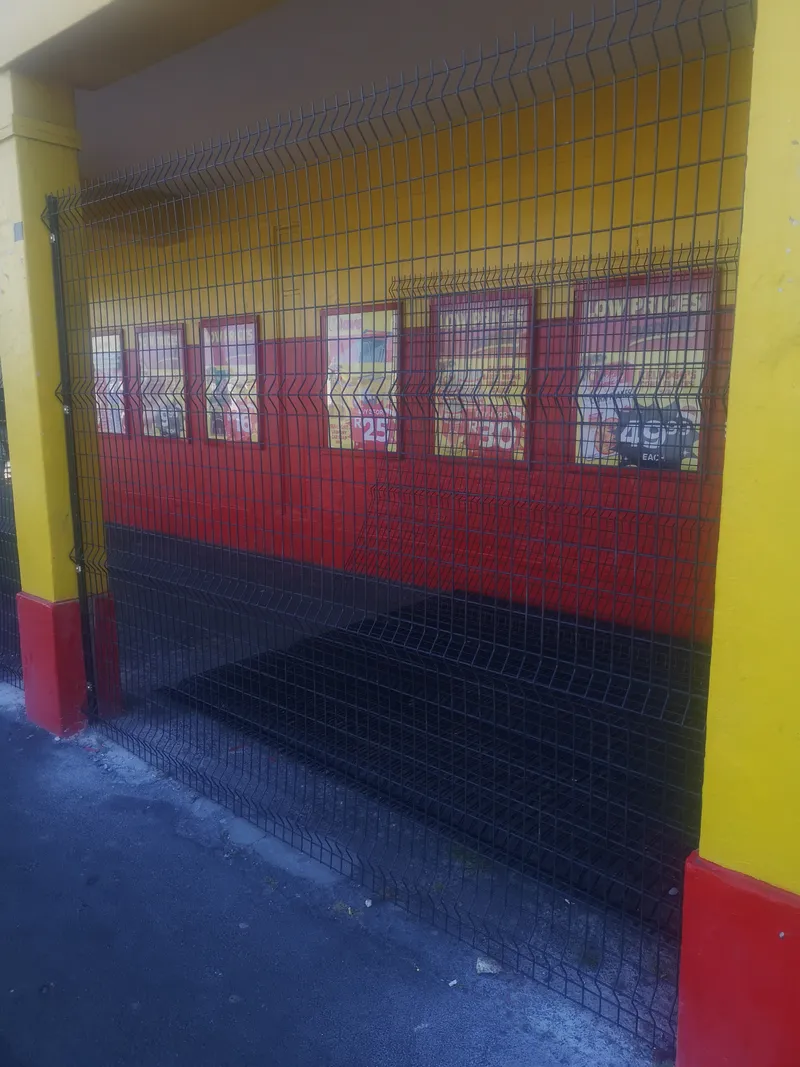 Clearview mesh fence covering shopfront with LOW PRICES promotional banners in Cape Town