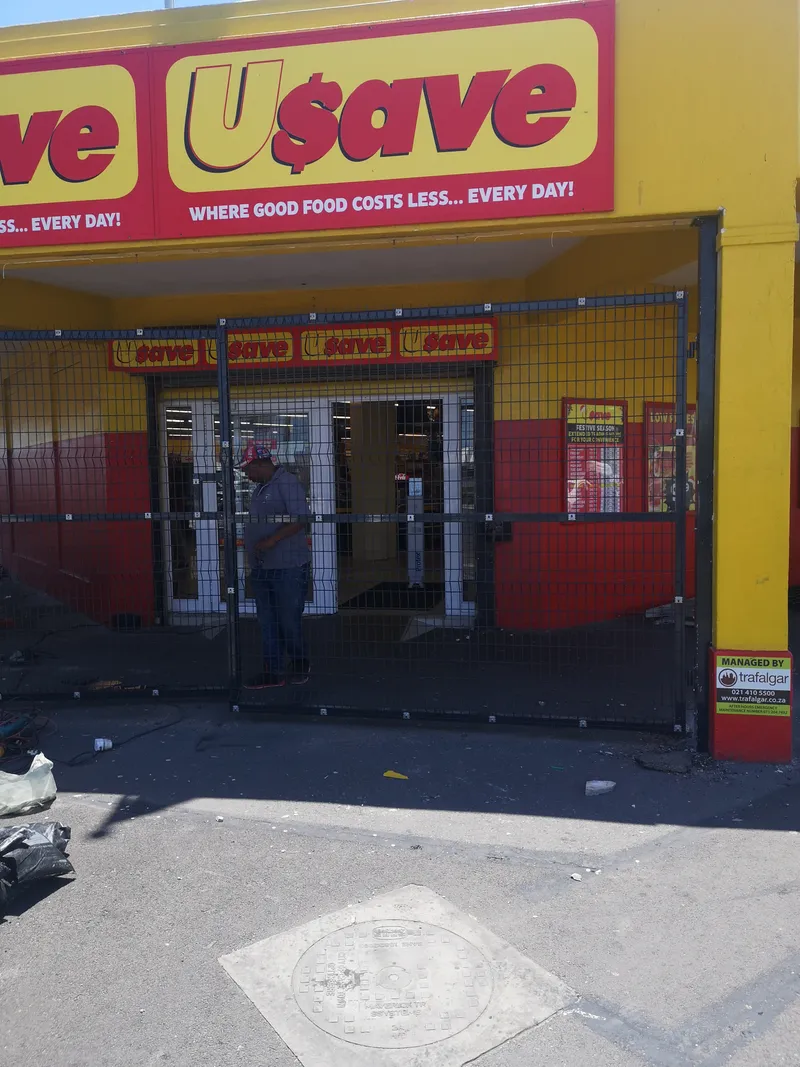 Worker fitting Clearview mesh swing gate at Usave supermarket entrance Cape Town