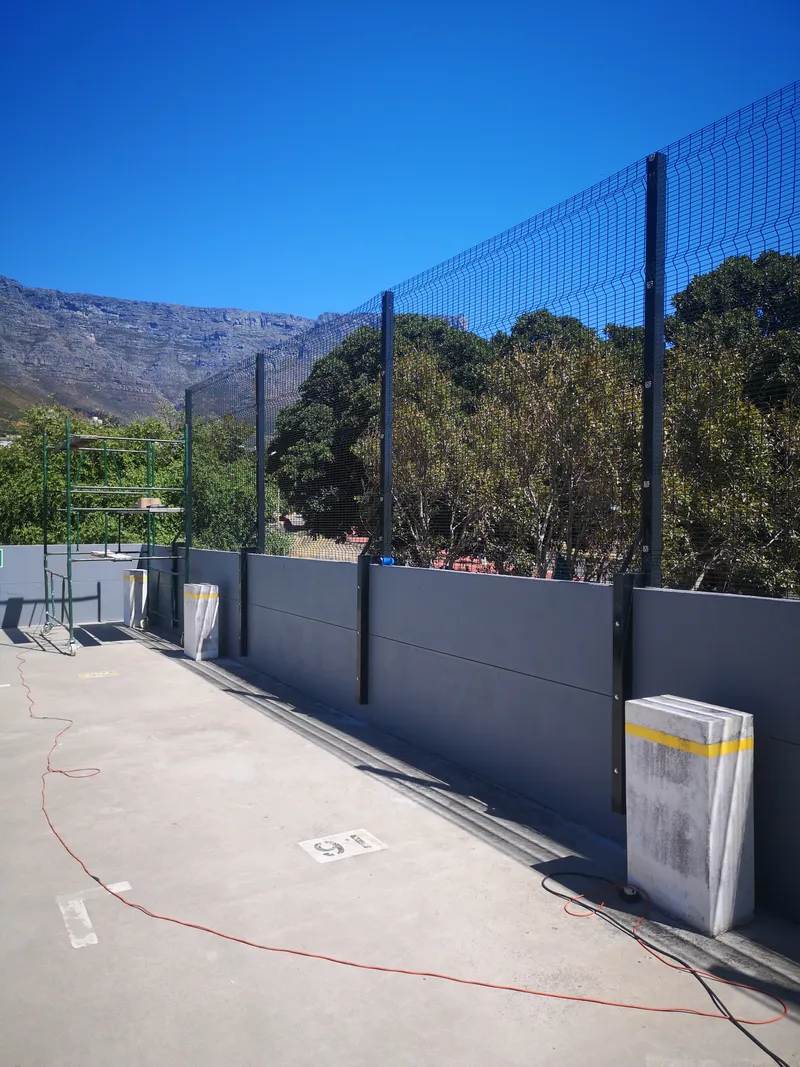 Clearview mesh fence installation on commercial rooftop with scaffolding in Cape Town