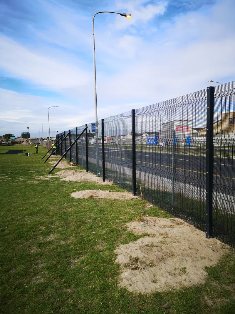 Clearview fence posts braced and panels being fitted along Cape Town roadside