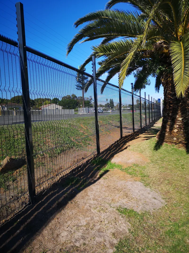 Black clearview anti-climb mesh fence installation alongside palm trees in Cape Town
