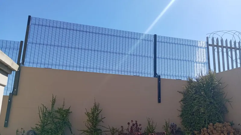 Black clearview mesh wall-topper extension on plaster boundary wall in Cape Town