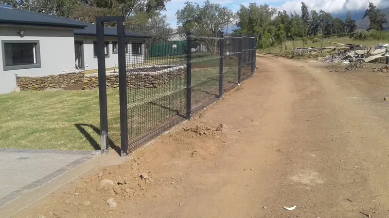 Clearview mesh fence installation in progress at modern country home with mountain views in the Western Cape