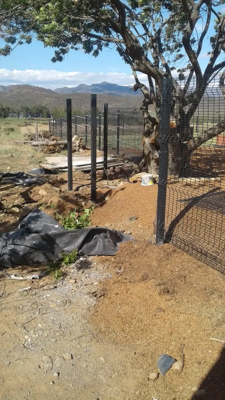 Clearview mesh fence posts being installed at farm property with mountain backdrop in the Western Cape