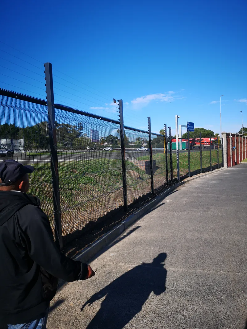 D&H Fencing team member inspecting completed clearview fence in Cape Town