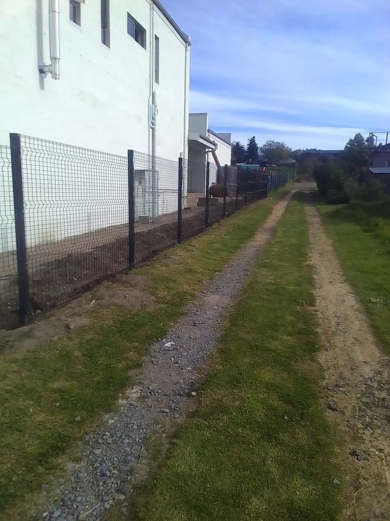 Clearview mesh fence along Cape Town commercial warehouse boundary on gravel access road