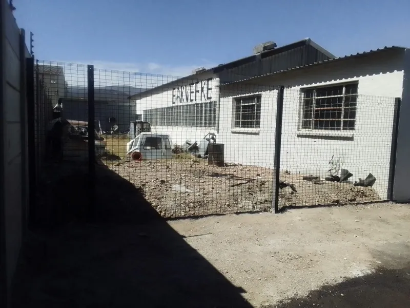 Black clearview mesh fence securing warehouse yard with white walls in Cape Town