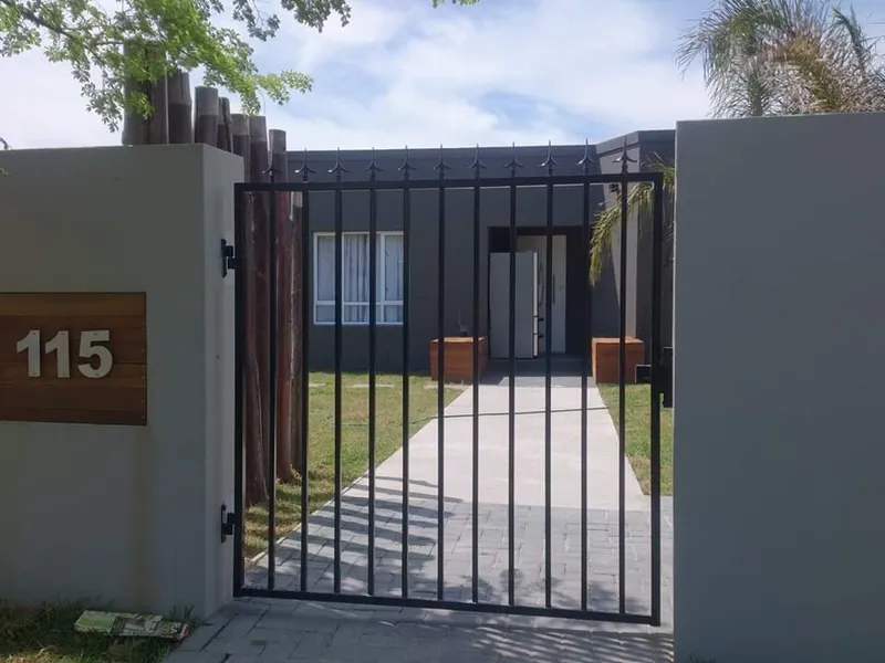 Black tubular steel pedestrian gate with spear tops installed at a modern residential home in Cape Town