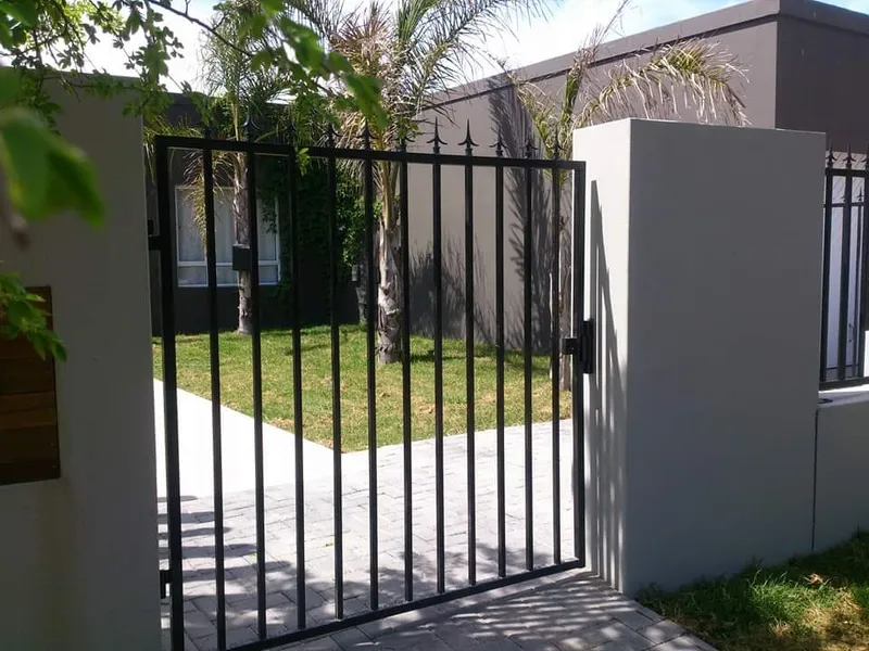 Black tubular bar pedestrian gate with decorative spear tops at a residential home in Cape Town