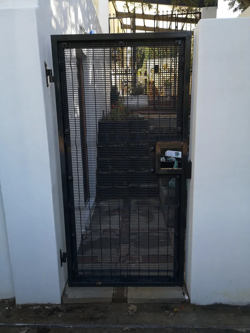 Black clearview mesh pedestrian gate with built-in letterbox on residential property in Cape Town