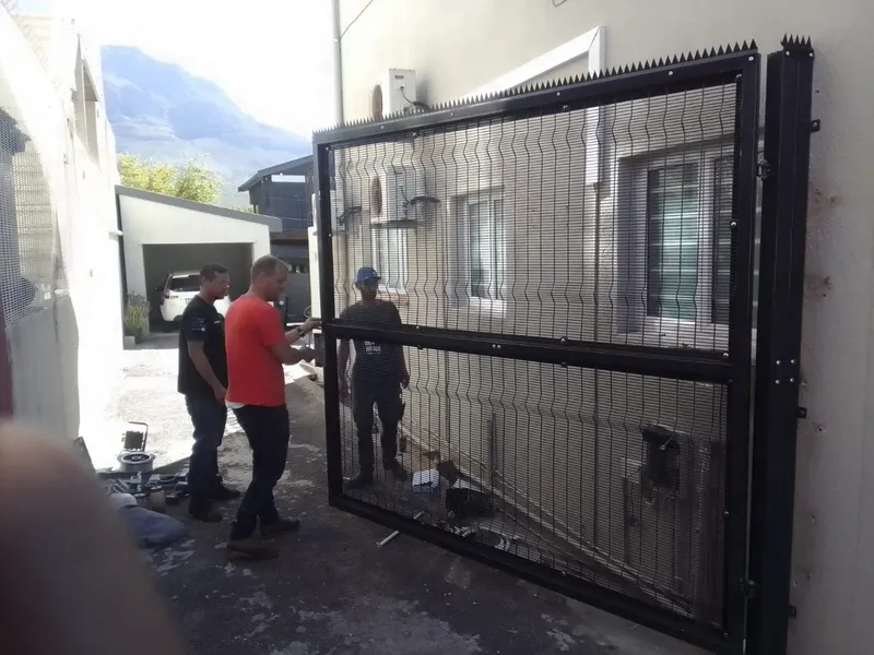 Black clearview mesh swing gate with anti-climb spike top against Cape Town mountain