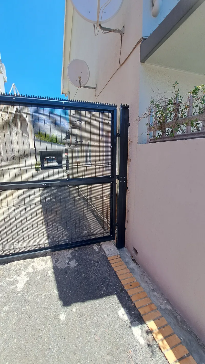 Black Clearview mesh sliding gate installation at a commercial entrance in Cape Town, Western Cape