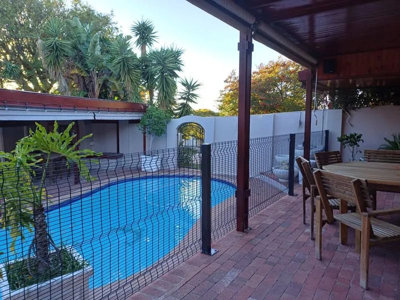 Pool safety mesh fence beside undercover patio at Cape Town home