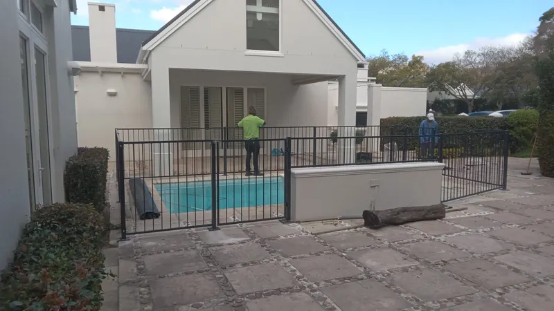 Steel bar pool fence at a Cape Town pool with a self-closing safety gate