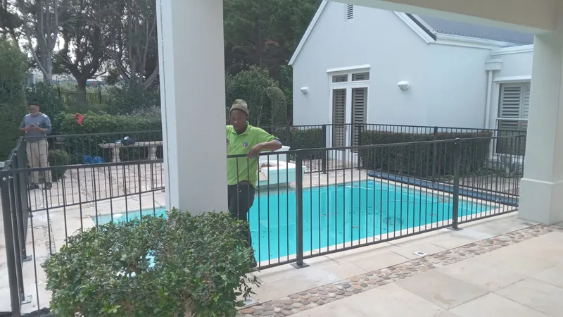 Steel bar pool fence at a Cape Town home during installation beside the swimming pool