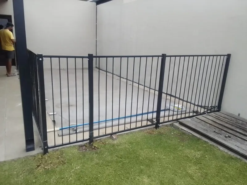 Steel bar pool fence at a Cape Town poolside garden boundary, black powder-coated