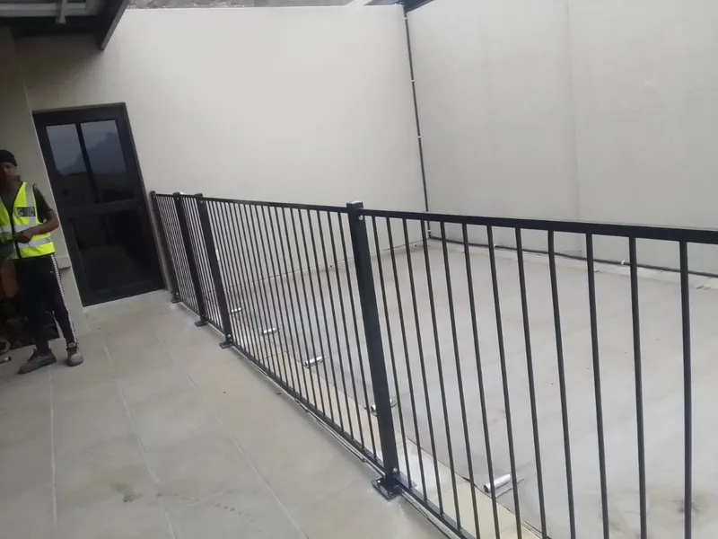Steel bar pool fence at a Cape Town raised terrace pool deck, black powder-coated bars