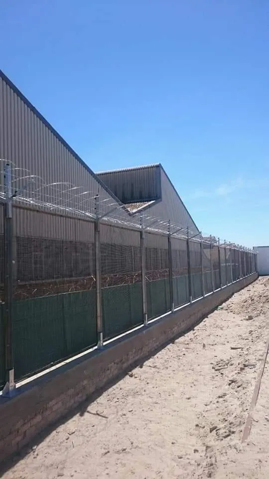 Warehouse perimeter security fence with welded mesh and razor wire topping at a Cape Town industrial site