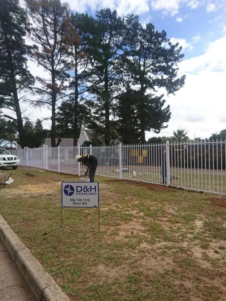 D&H Fencing installer working on white tubular bar fence at residential property in Cape Town