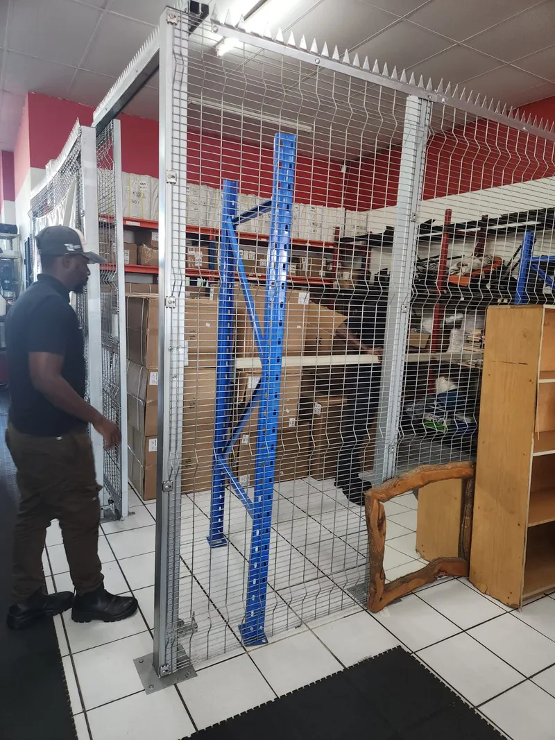 Galvanised welded mesh stockroom cage with hinged gate inside Cape Town commercial warehouse