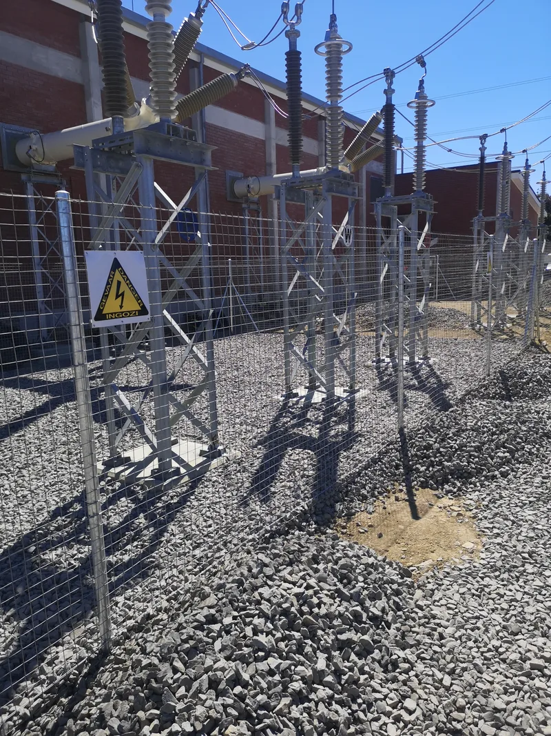 Galvanised welded mesh fence enclosing high-voltage transformers at Cape Town electrical substation